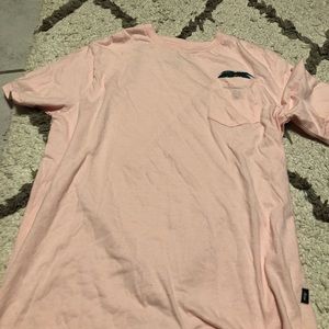 It’s a pink shirt with a palm tree sticking out of a pocket on the left side!
